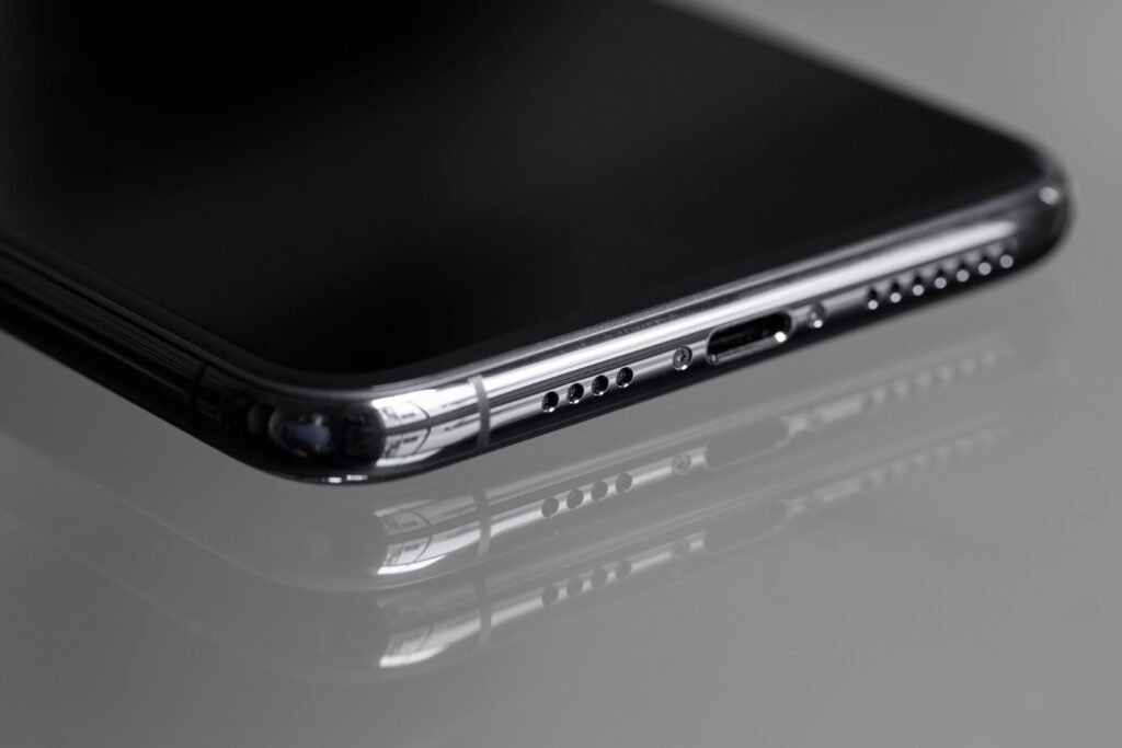 Detailed close-up of a smartphone's edge with a reflective surface, emphasizing sleek design.