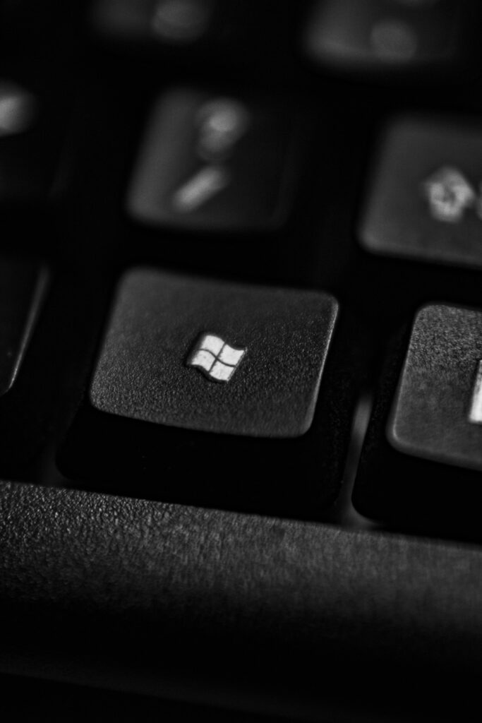 High-quality close-up of a Windows logo key on a black plastic keyboard.