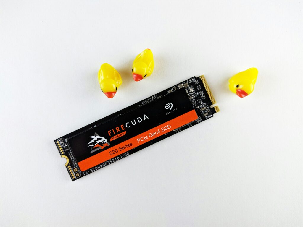 Close-up of a Seagate FireCuda SSD on a white background with three yellow rubber ducks.