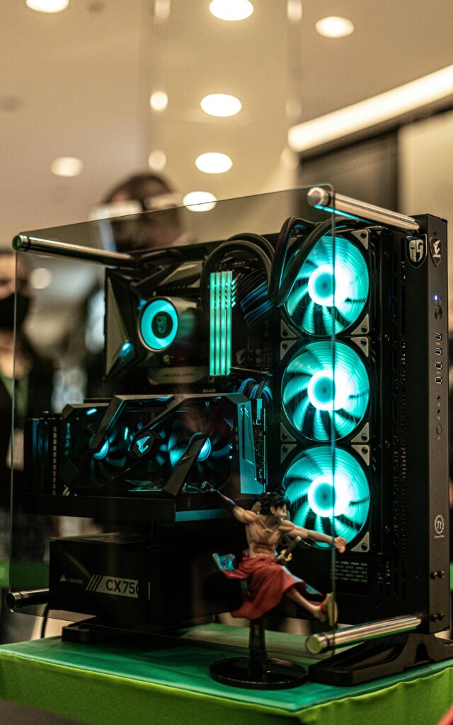 Vertical shot of a powerful gaming PC with illuminated RGB components on display indoors.