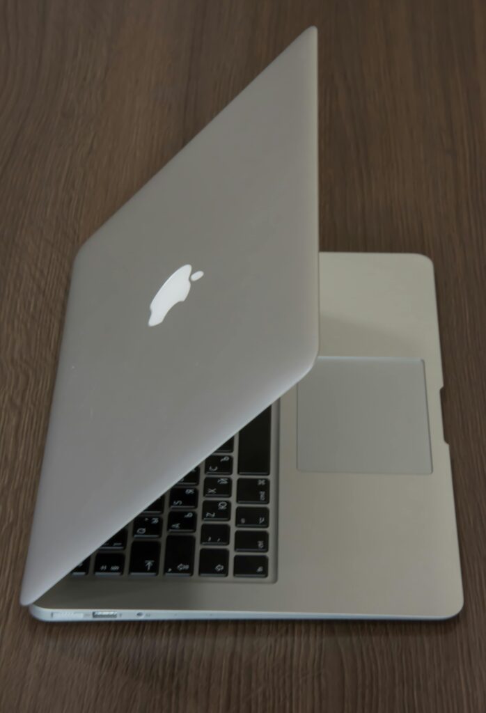 An angled view of a sleek laptop on a wooden table, emphasizing technology.